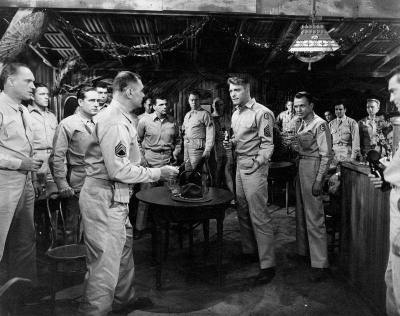 Burt Lancaster and Deborah Kerr stand on a beach surrounded by crew members on the set of the film 'From Here to Eternity,' 1953.