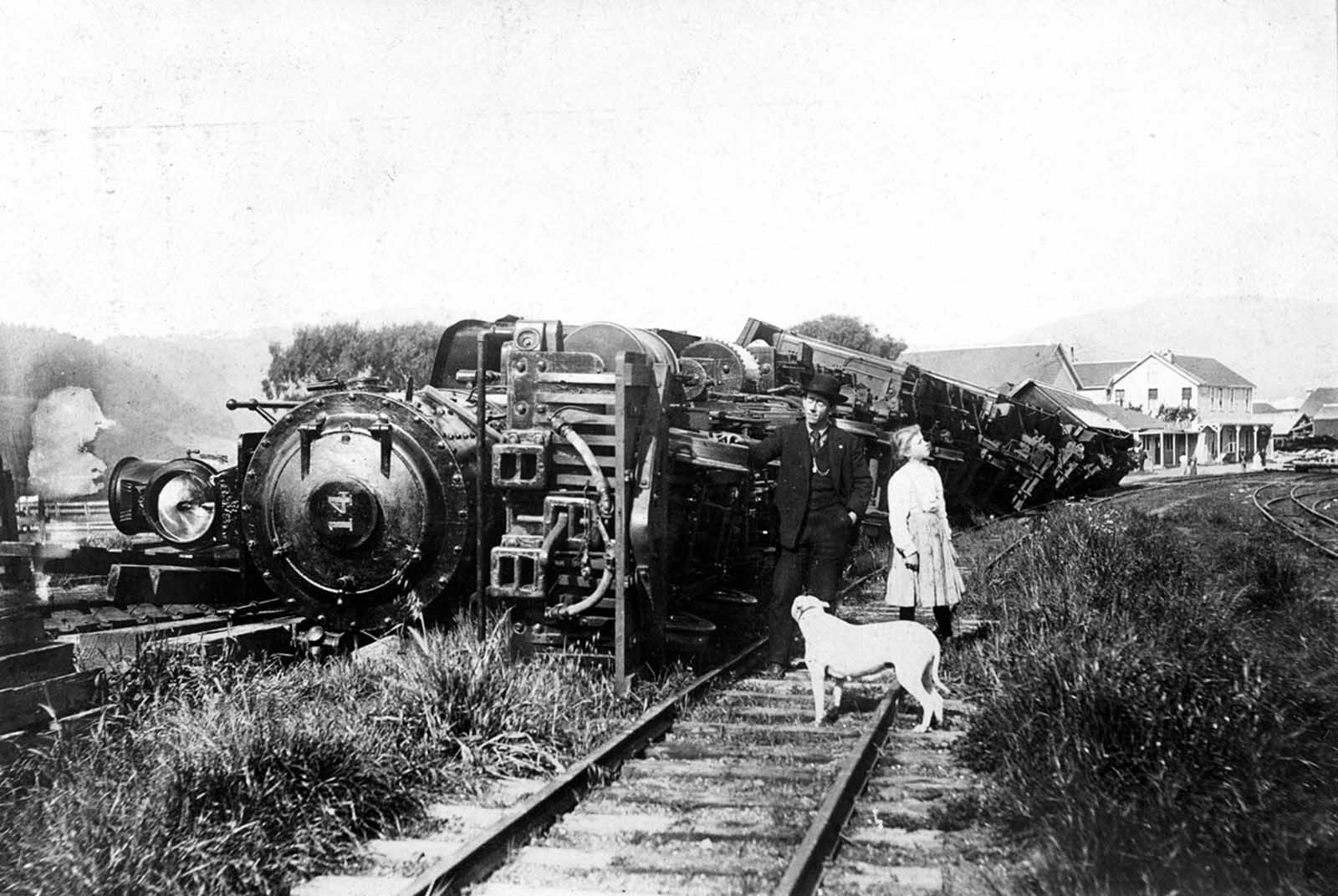 A train thrown down by the earthquake at Point Reyes Station. The train was standing on a siding. Beyond are the buildings of the Point Reyes Hotel and, on the extreme right, the ruin of a stone store which was shaken down.