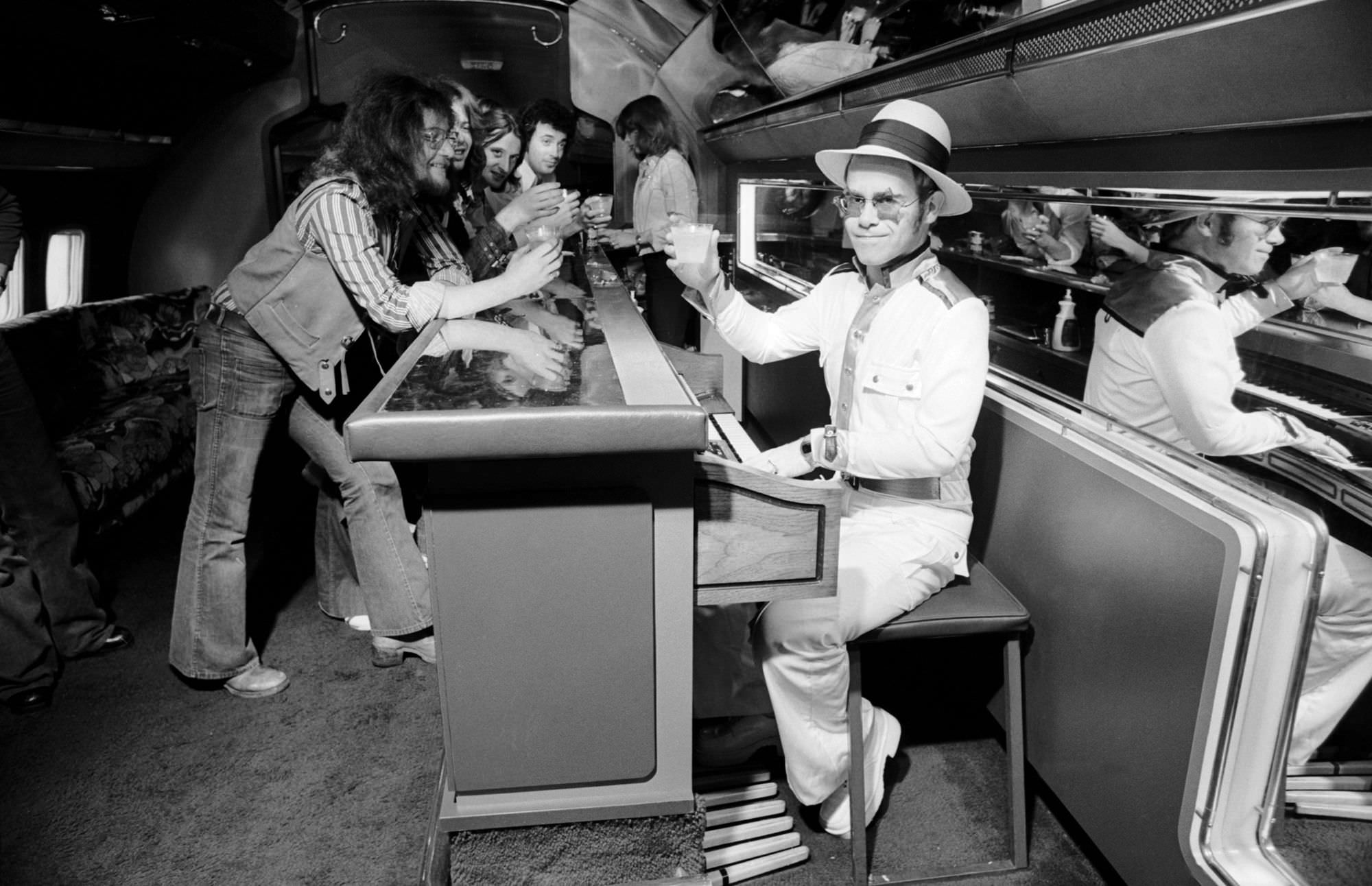Elton John travelling on his a private jet, complete with a piano bar, 1974