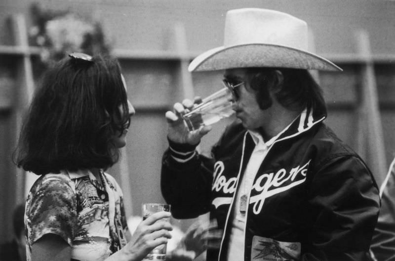 Elton John chats with music journalist Lisa Robinson after a concert on the the Rolling Stones' Tour of the Americas in 1975