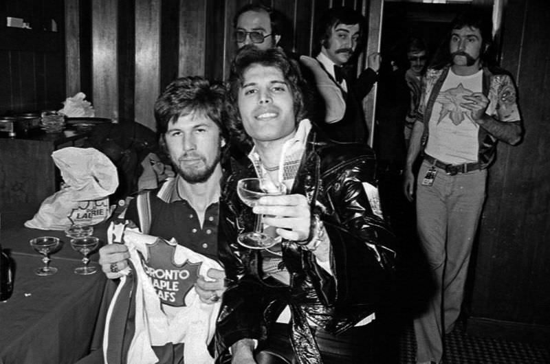 Queen holds up the Toronto Maple Leaf jerseys they were gifted while performing in Canada in 1977
