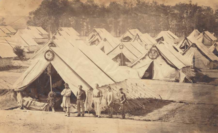 Several men stand near a battlefield hospital.
