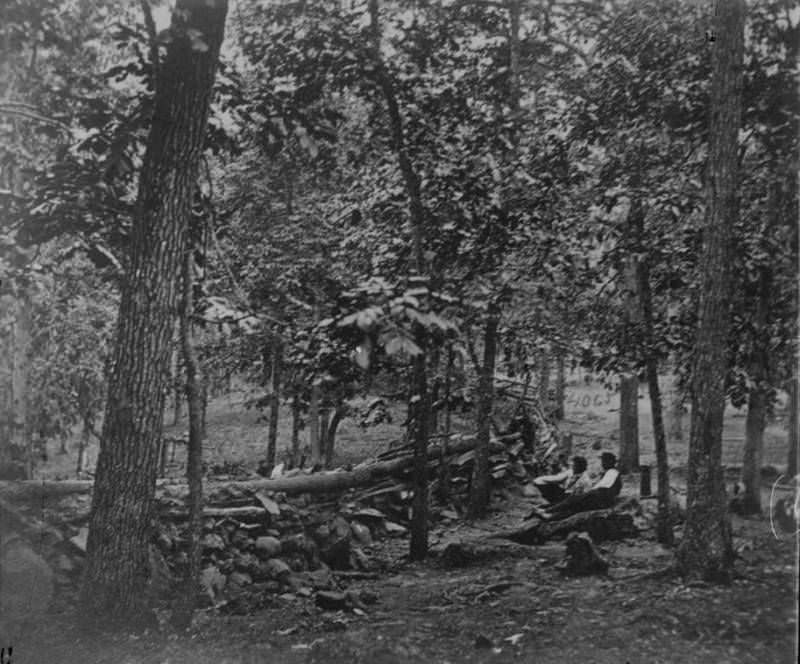 Two Union soldiers rest behind defensive fortifications during the Battle of Gettysburg.