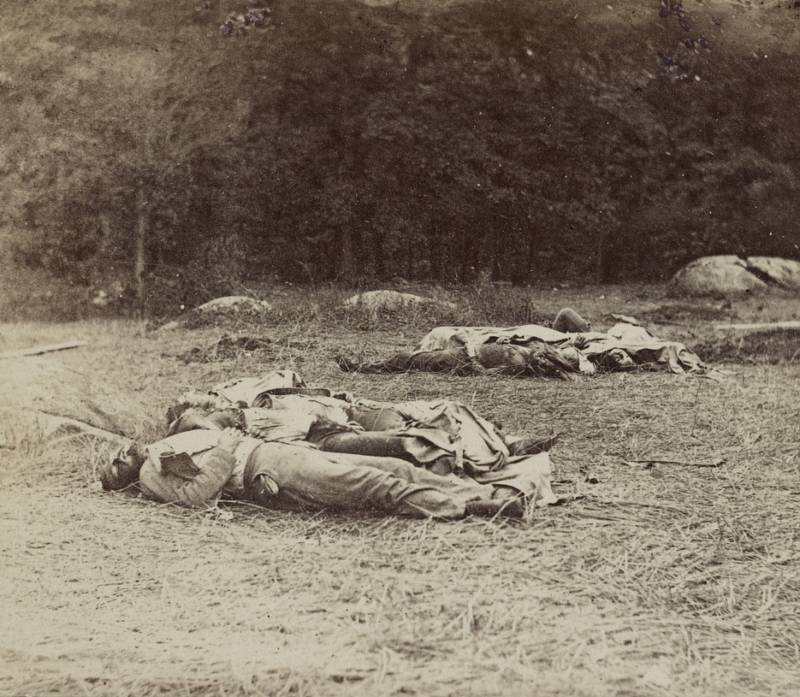 A field is strewn with the bodies of Confederates.