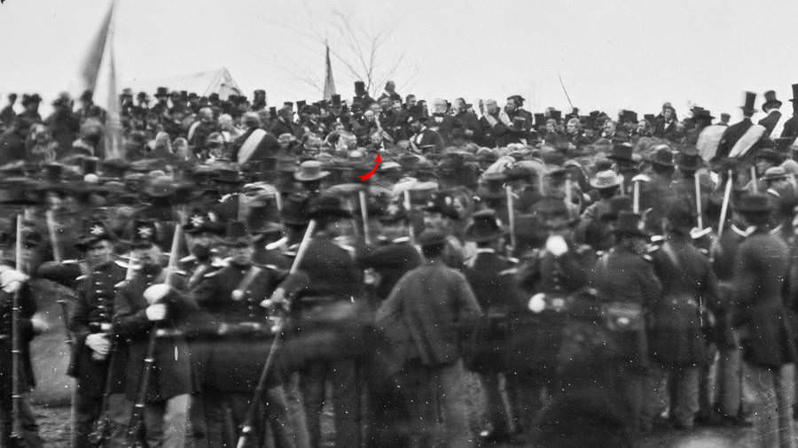 Abraham Lincoln (identified by red arrow) stands among the crowd before delivering the Gettysburg Address.