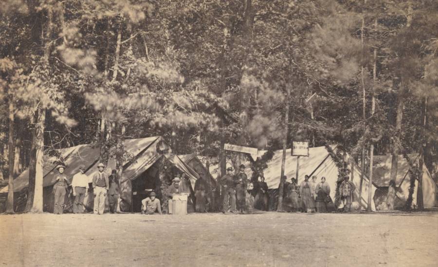 People stand in front of the Battle of Gettysburg tents belonging to the U.S. Christian Commission, a group that provided supplies and services to Union troops.