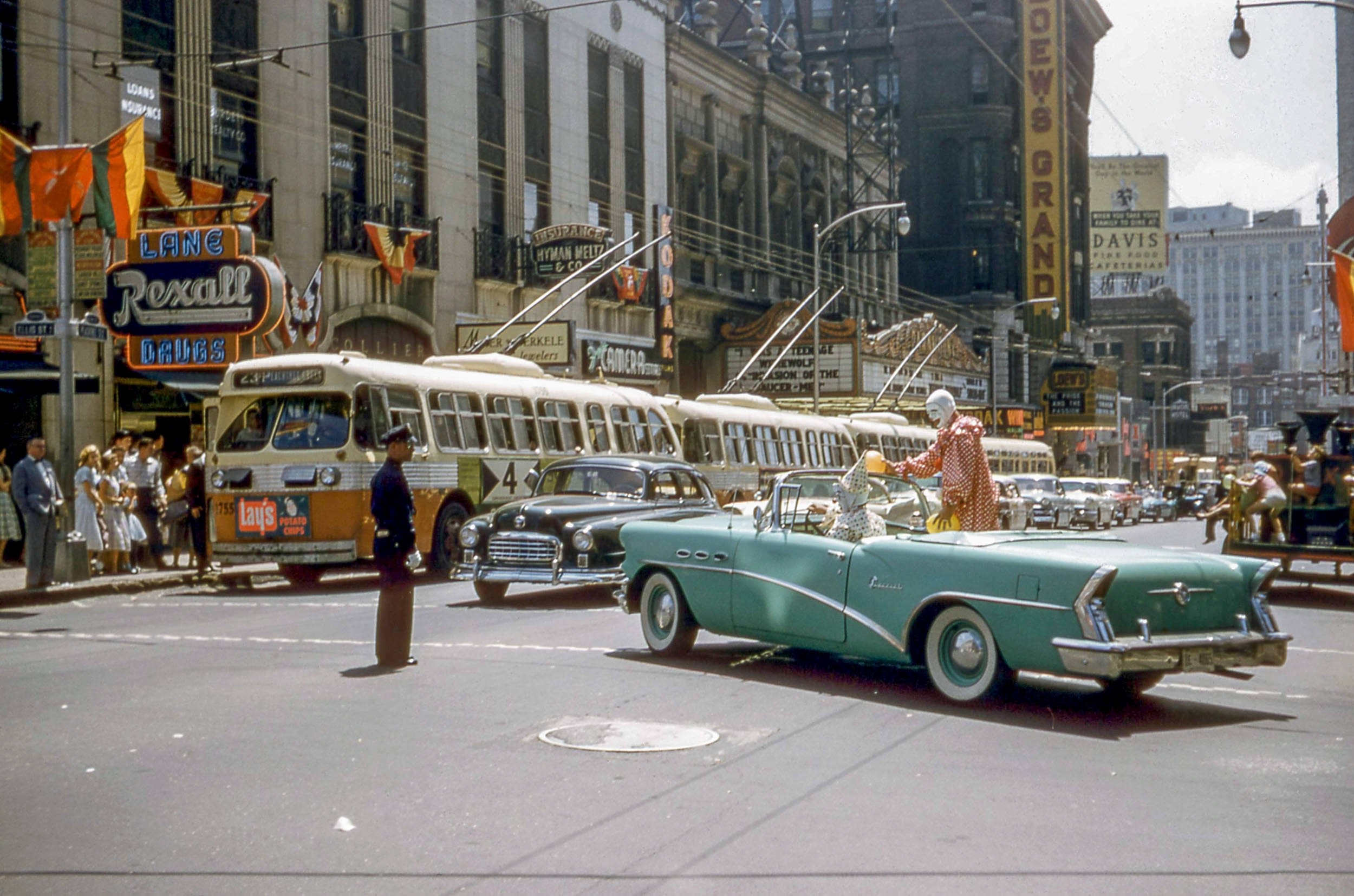 Clowns in a car for the Shriners' Annual Convention on Peachtree St. NW at Ellis St NE in Atlanta, August 30, 1957