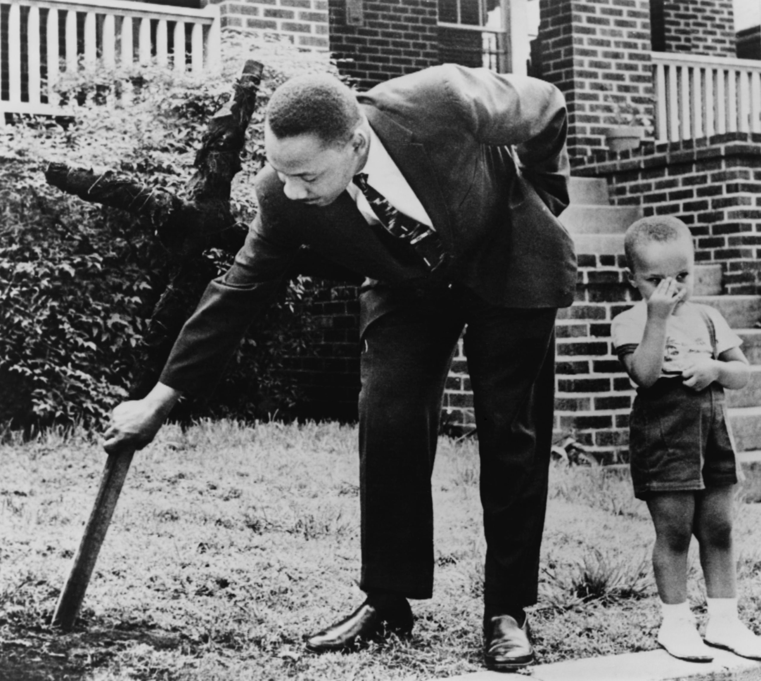 Dr. Martin Luther King Jr., removing a burnt out cross from his lawn, Atlanta, Georgia, 1960