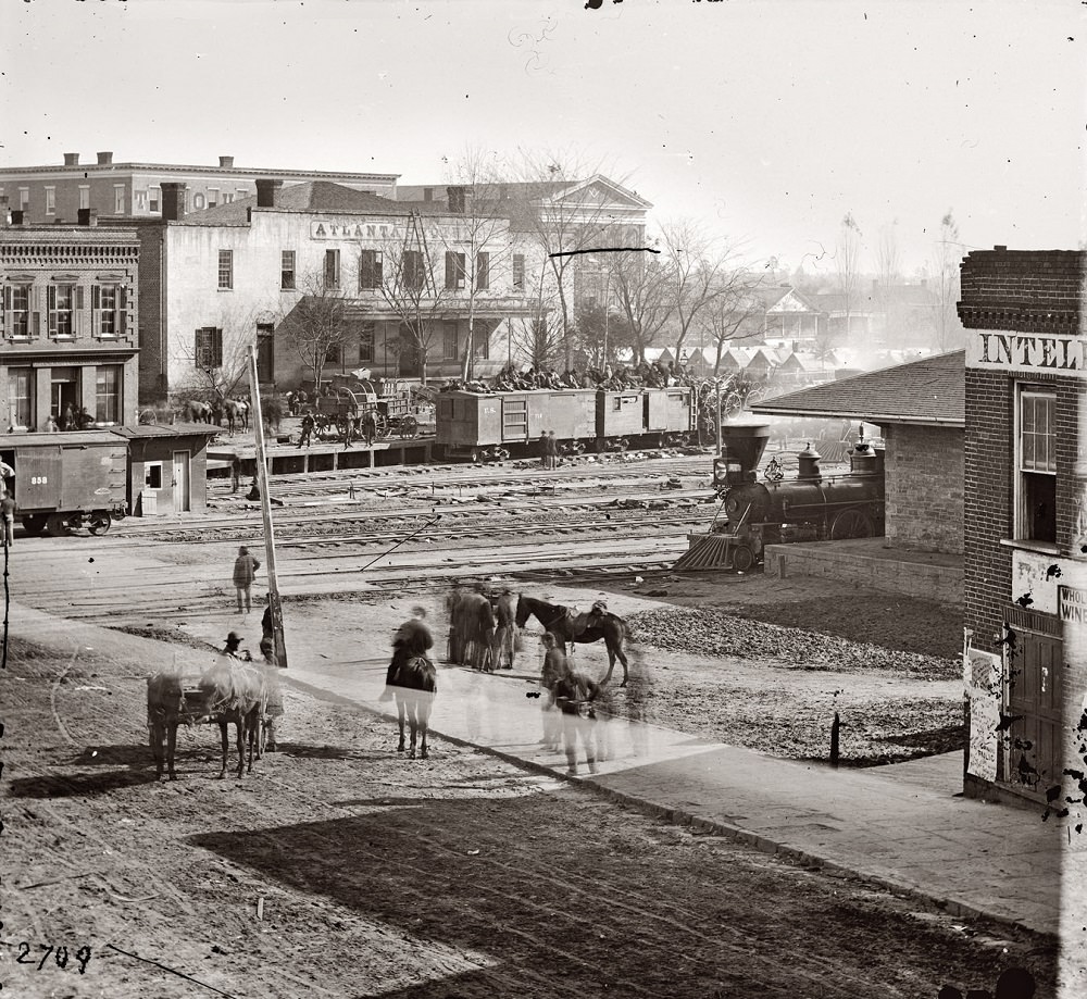 Union soldiers on boxcars at railroad depot next to offices of the Atlanta Intelligencer during the city's occupation by General Sherman