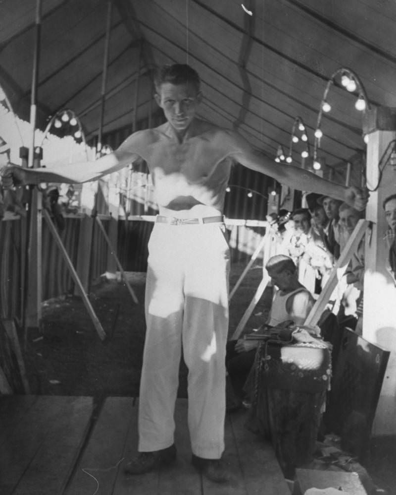Silas Whaley, the man without a stomach, pulling his stomach in so far it seems like he doesn't have one as he awes onlookers in carnival sideshow at the Greenbrier Valley Fair, 1938