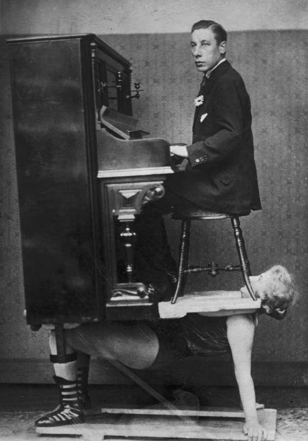 A circus strongwoman balances a piano and pianist on her chest, 1920