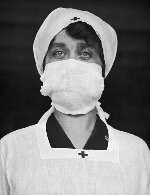 A U.S. Red Cross employee wears a face mask in an attempt to help decrease the spread of influenza, 1918