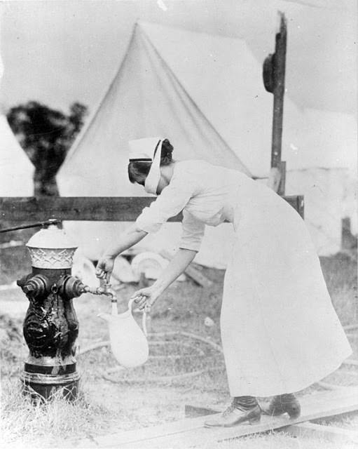 A nurse protects herself while fetching water, September 13 1918.