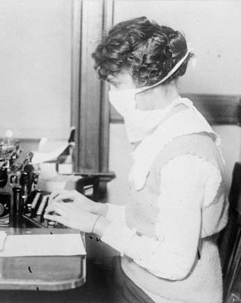 A typist works while wearing a mask, in New York City, October 16 1918.