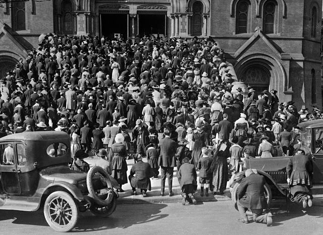 The congregation prays on the steps of the Cathedral of Saint Mary of the Assumption, where they gathered to attend mass and pray during the influenza epidemic, in San Francisco, California.