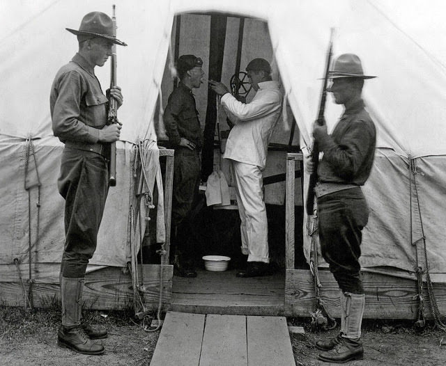 An American soldier has his throat sprayed to prevent influenza in December of 1918 at Love Field in Dallas, Texas.