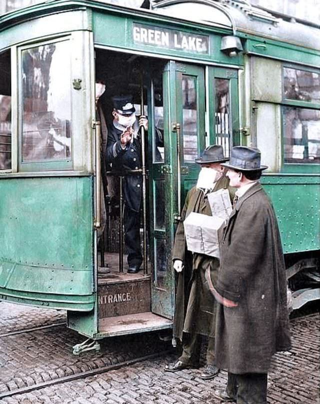 A conductor checks to see if potential passengers are wearing required masks in Seattle, 1918.