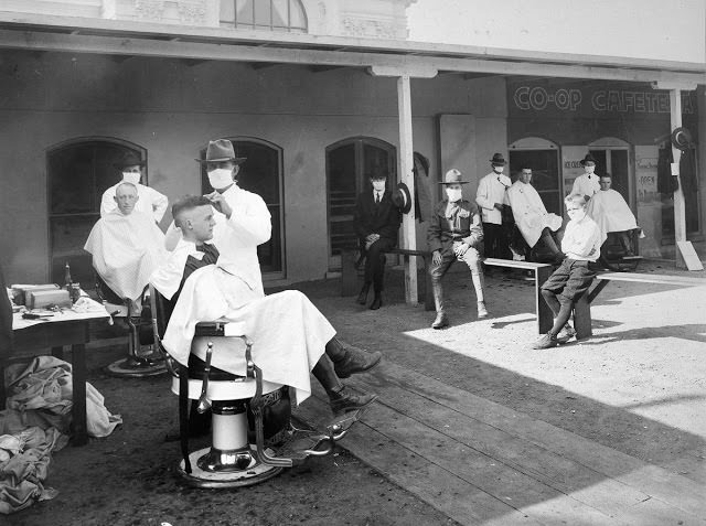 An open-air barber shop. Public events were encouraged to be held outdoors to hinder the spread of the disease during the influenza epidemic. Photographed at the University of California, Berkeley, in 1919.
