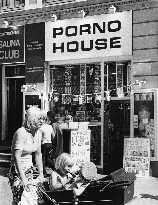 Street scene showing a sex shop and massage parlour titled 'Porno House', New York City, 1975.