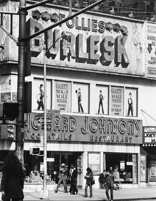 The 'Follies Burlesk' showing the upcoming show for the 'Gaiety Male Theater' above 'Howard Johnson's' restaurant on 46th St. and Broadway, New York City, 1978.