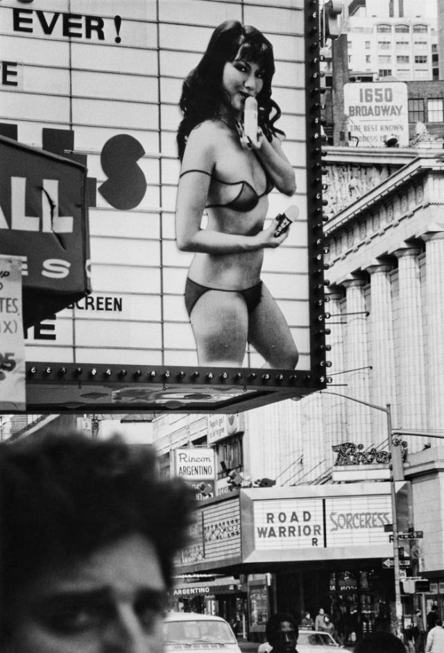 Cinema signs on the Rivoli Theatre and surrounding cinemas on Broadway advertising adult films and shows, New York City, 1983.