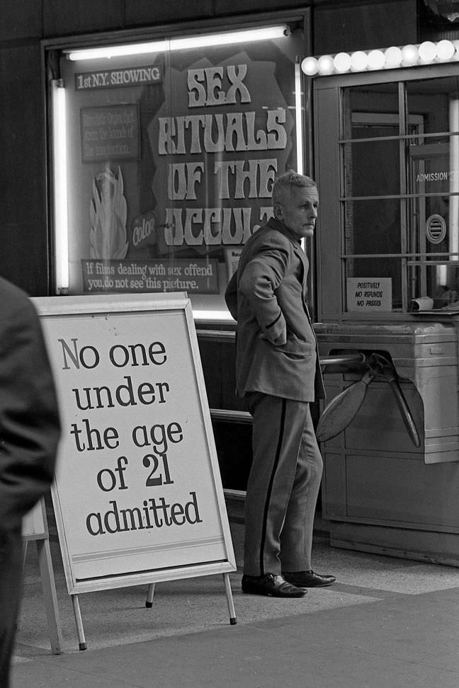 An usher stands near the box office of a movie theater that screens pornography films. No one under the age of 21 would be let in.