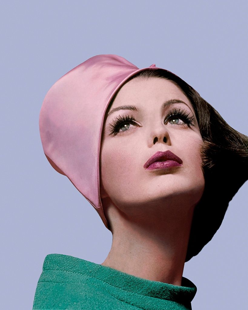 Fashion model Dorothea McGowan, in cloche of pink satin, Vogue 1962