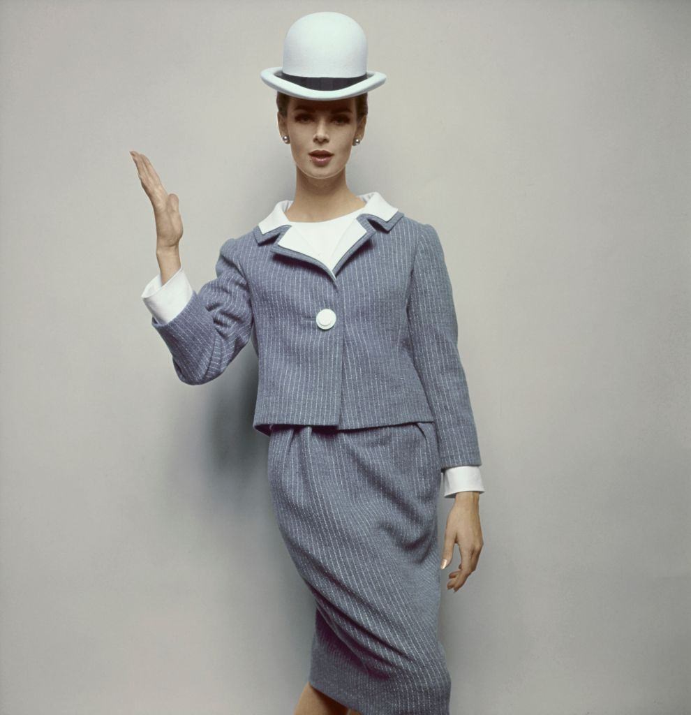 Model wearing grey pinstripe skirt suit by Talmack, with white pique blouse, Vogue 1963