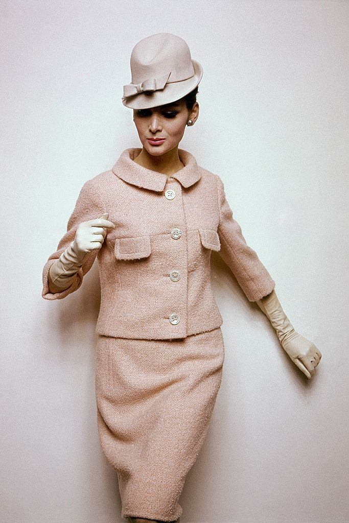 Model wearing skirt suit in pale apricot boucle, Vogue 1963