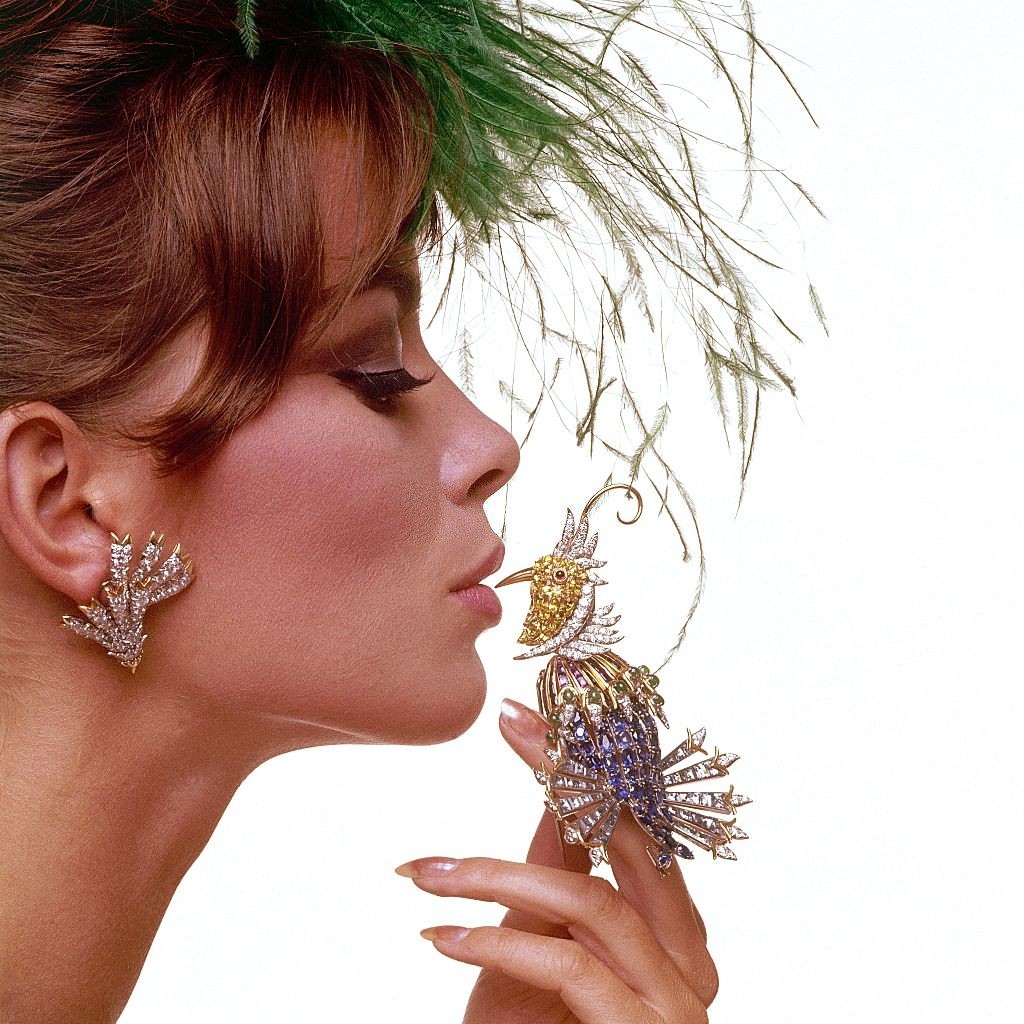 Fashion model holding jeweled bird made-up of precious and semi-precious stones, Vogu 1963
