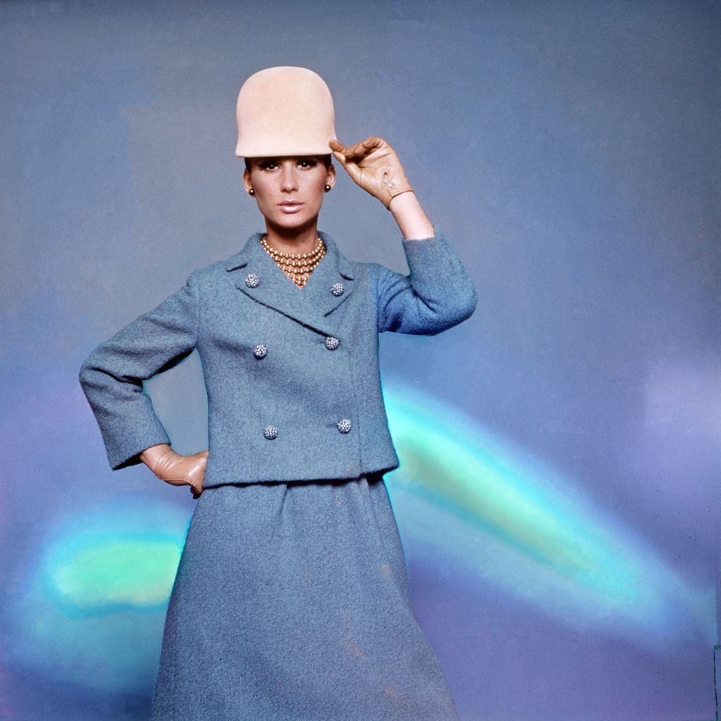 Model wearing an azure blue dirndl suit with cockleshell buttons on a small double breasted jacket, Vogue 1965