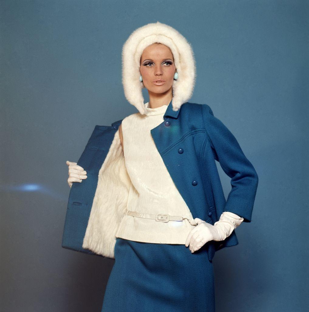 Model Veruschka wearing a David Kidd for Jablow mink-lined wool suit with a moire belted top and Amrose hat, Vogue 1965