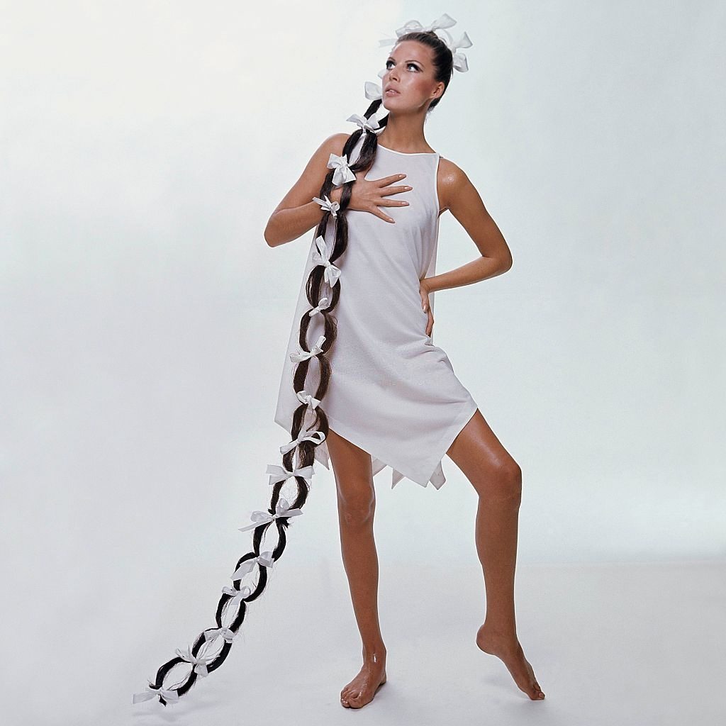 Model sporting floor-length hairpiece wearing white sleeveless handkerchief, Vogue 1966