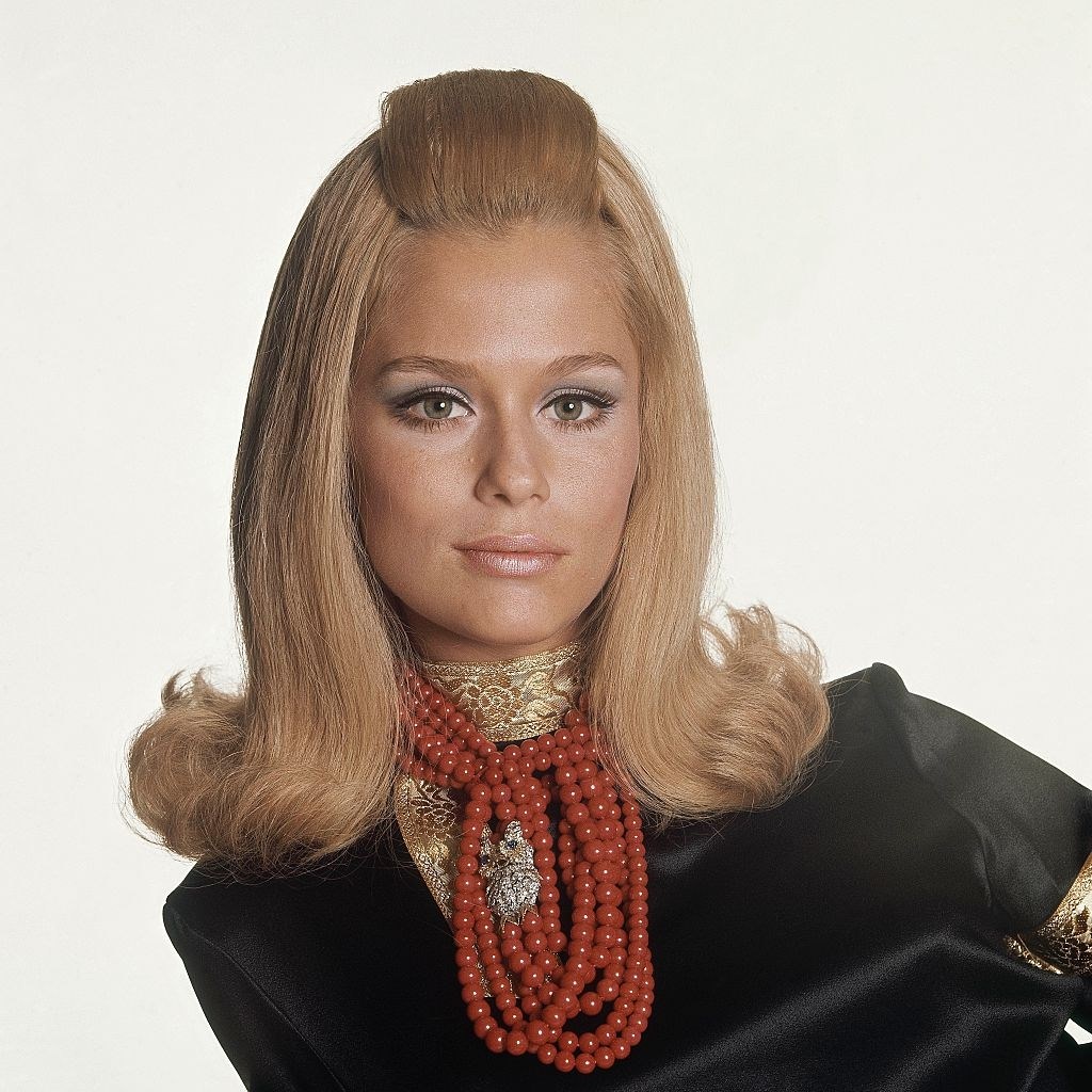 Model Lauren Hutton wearing black satin cossack's blouse by Lynn Stuart for Mister Pants, Vogue 1966