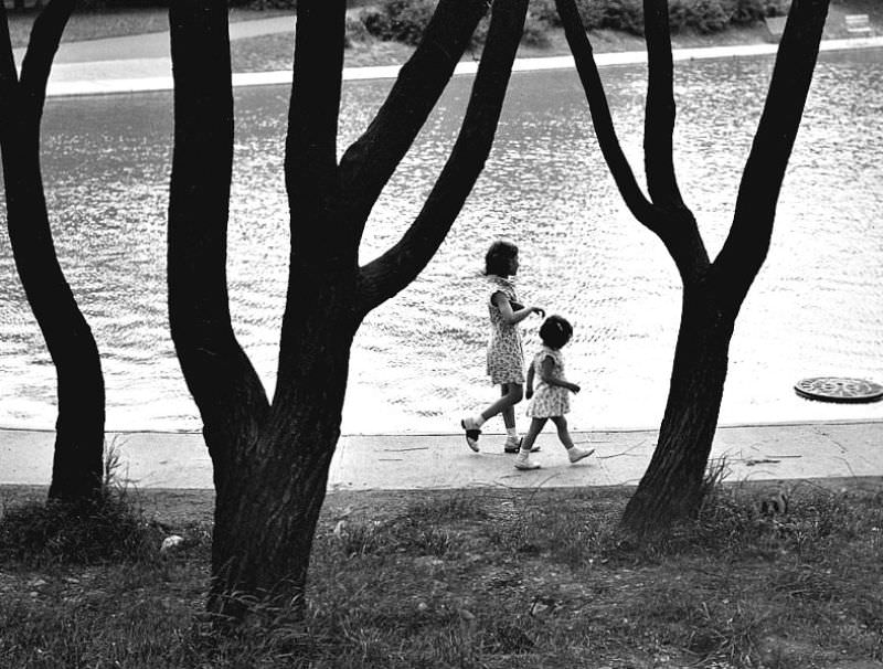 Two children walk around the reflecting pool in Eden Park, June 10th, 1939