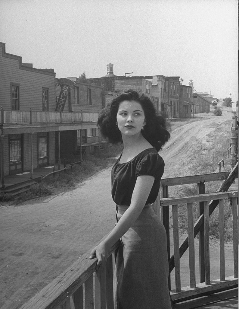 Debra Paget, standing on a balcony in the middle of the desolate town.