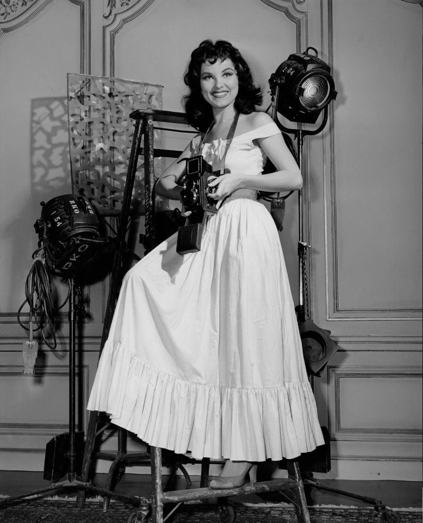 Debra Paget takes photographs on the set of the Panoramic Productions film 'The Gambler from Natchez', 1954