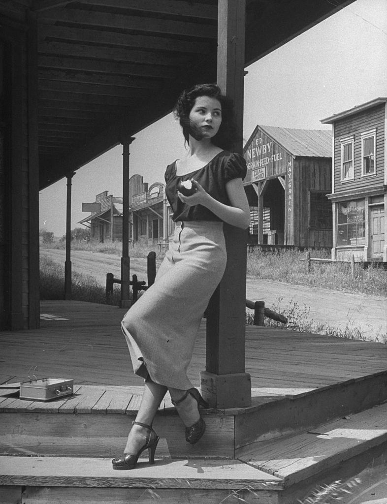 Debra Paget, eating an apple in the shade.