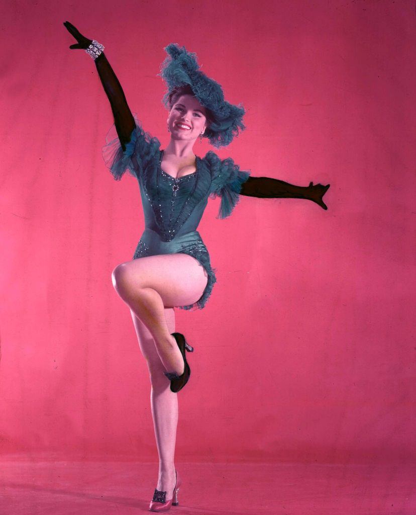 Debra Paget wearing a green showgirl costume of ostrich feathered hat and embroidered bodice, Circa 1950