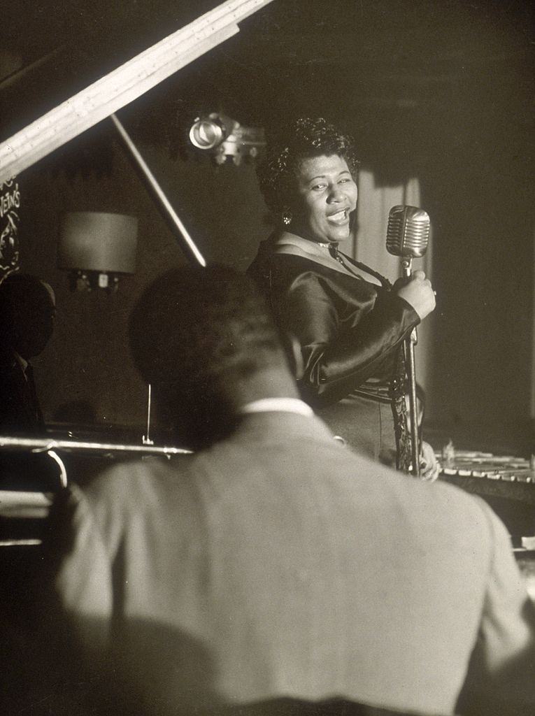 Ella Fitzgerald peforming at the microphone with piano accompanist at Storyville, New York City, 1952
