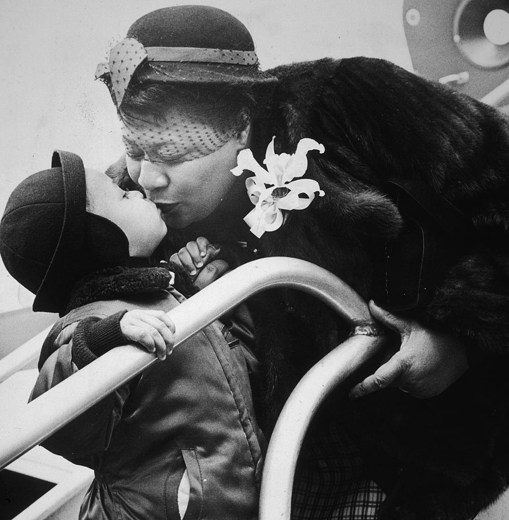 Ella Fitzgerald leans over to kiss an unidentified young boy, 1955