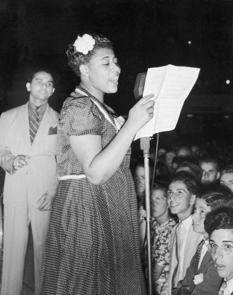 Ella Fitzgerald sings while holding sheet music on stage with American bandleader, Asbury Park Casino, 1938