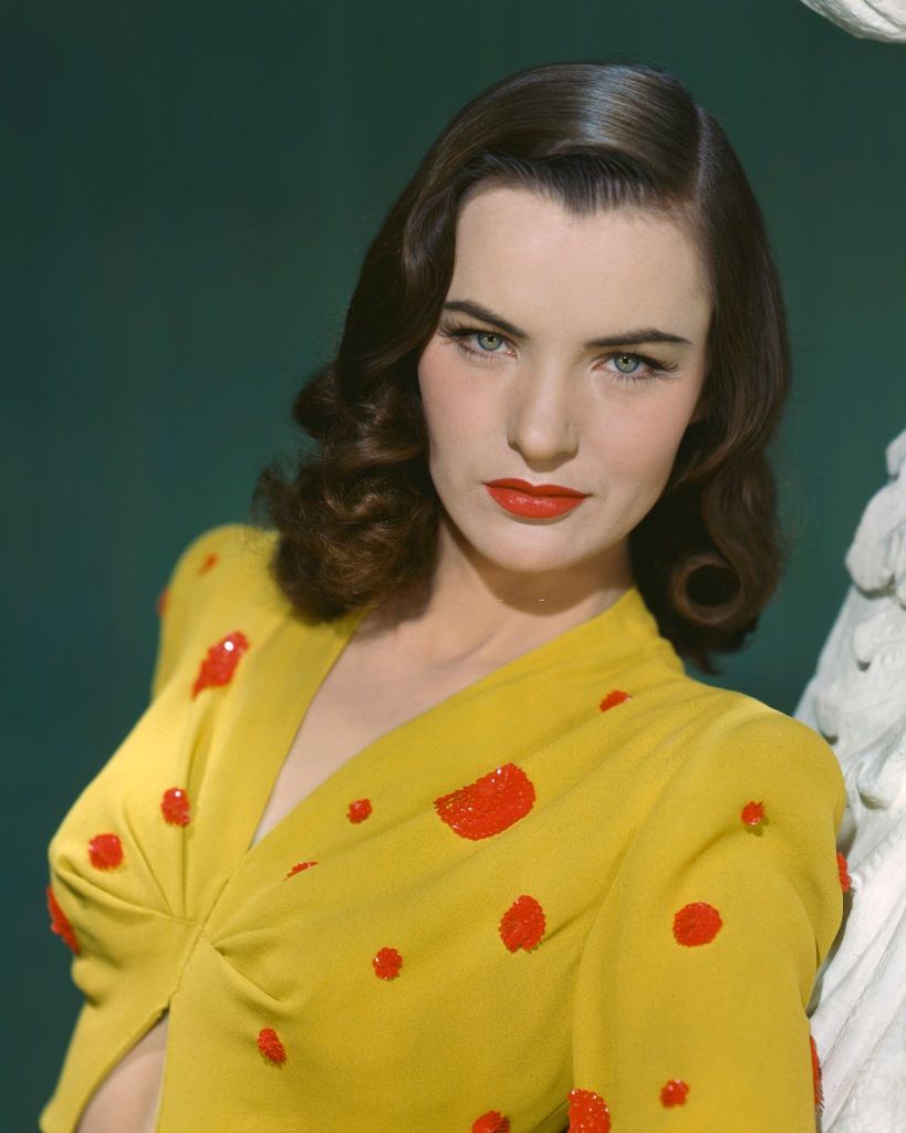 Ella Raines in a midriff-baring, yellow top with red sequins, 1940s