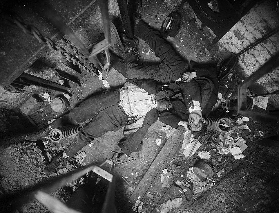 The bodies of Robert Green (left), an elevator operator, and Jacob Jagendorf (right), a building engineer, lie at the bottom of an elevator shaft November 24, 1915, following the pair's alleged failed robbery attempt