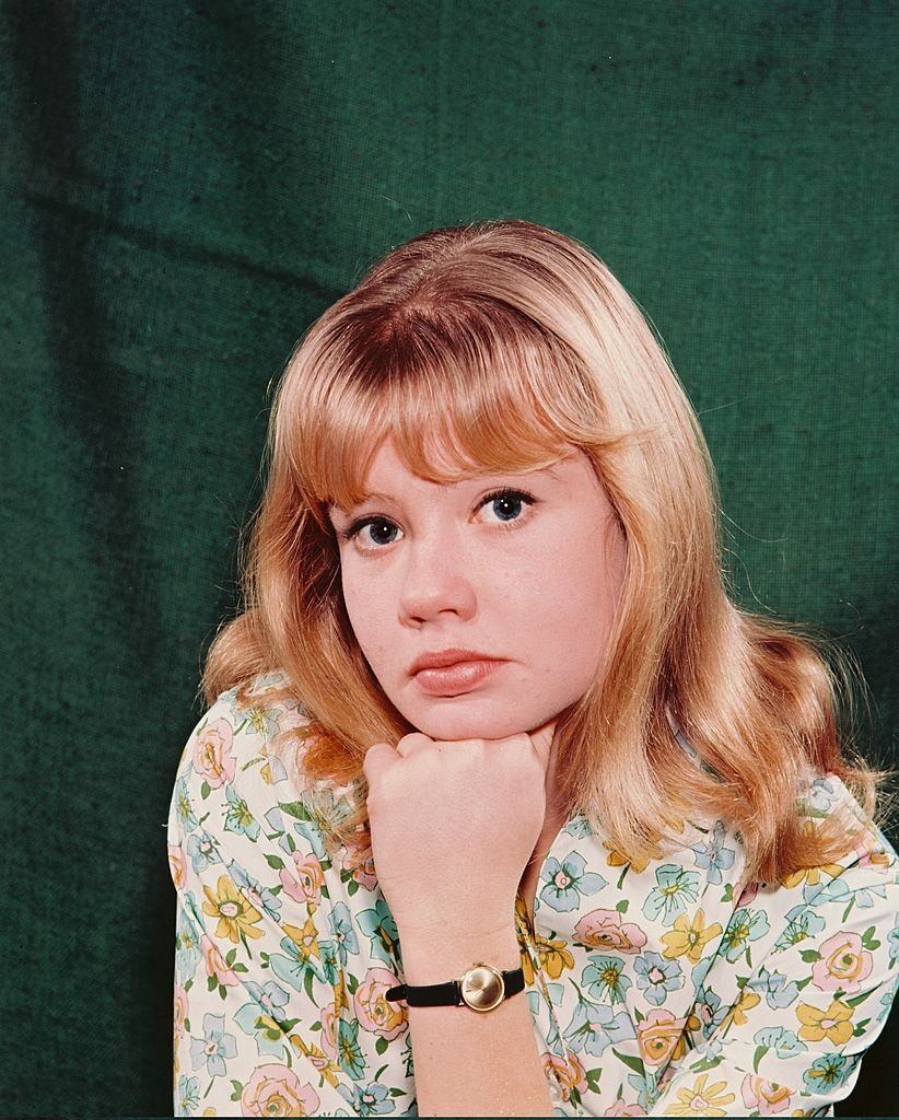 Hayley Mills wearing floral patterned blouse, with her chin resting on her hand, 1960