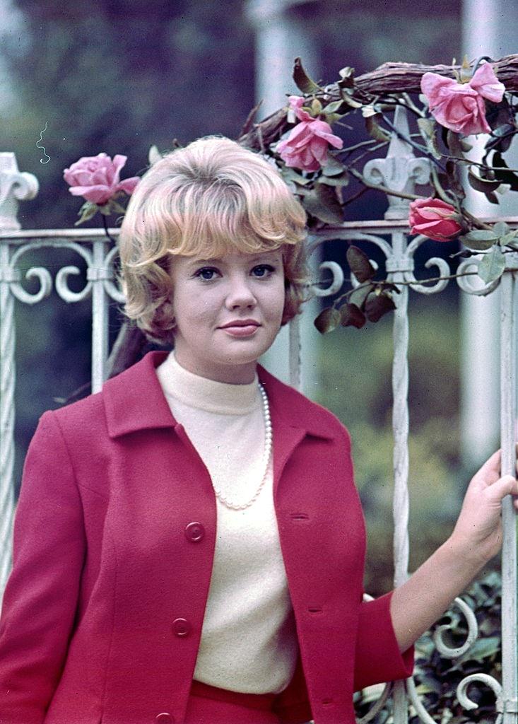 Hayley Mills at the airport wearing pink with a black and white striped sweater, 1970