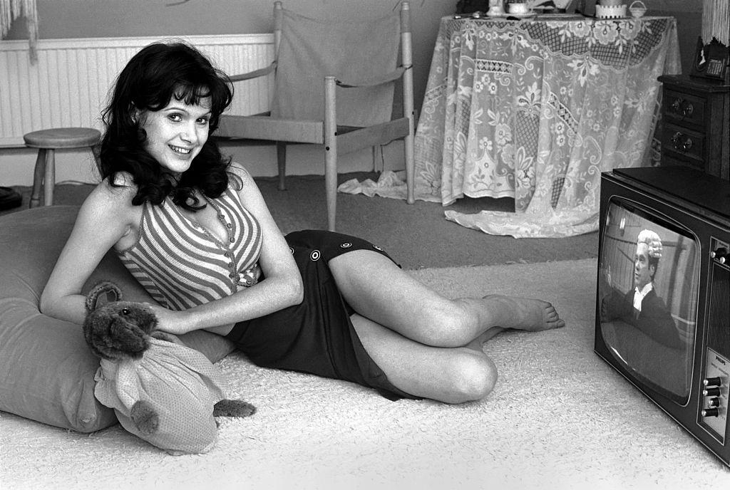 Actress Madeline Smith watching television at her flat in Kew, 1974. 