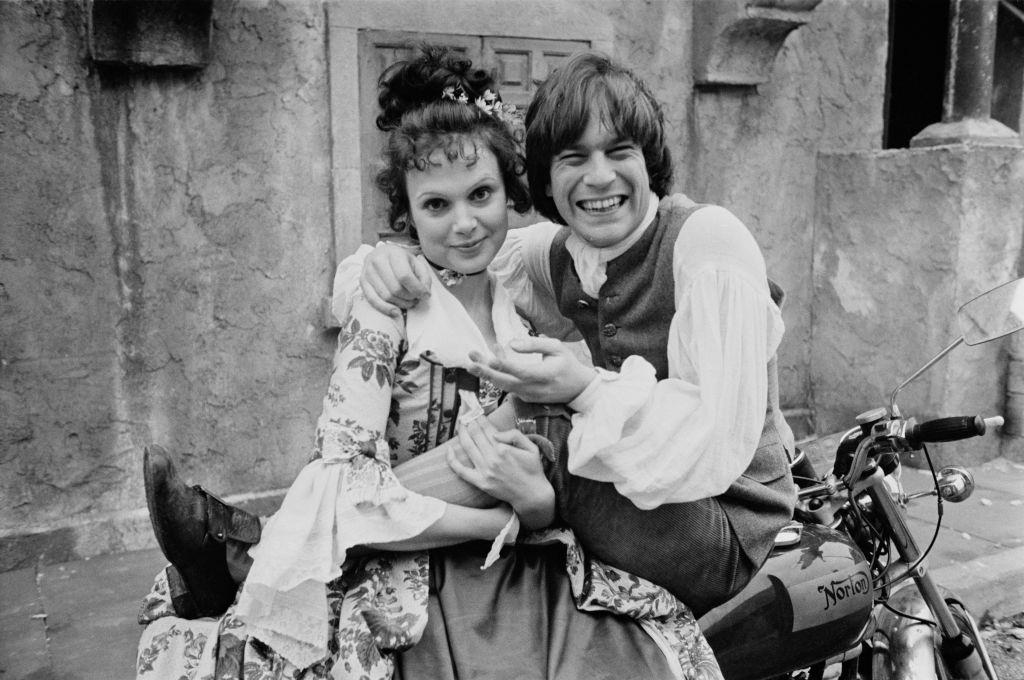 Madeline Smith with Nicky Hanson ' on a motorcycle on the set of British comedy film 'The Bawdy Adventures of Tom Jones', 1975