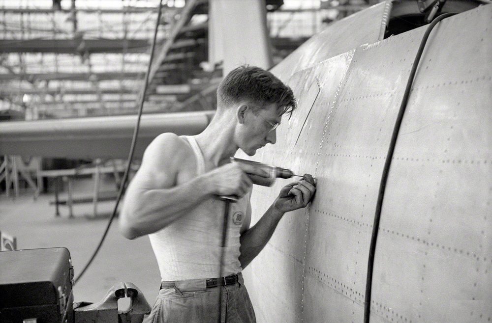 A man drilling holes for rivets in a fuselage on a sub-assembly line, Nashville, Tennessee, August 1942