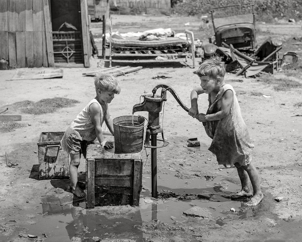 Children of May Avenue camp pumping water from thirty-foot well which supplies about a dozen families, Oklahoma City, July 1939